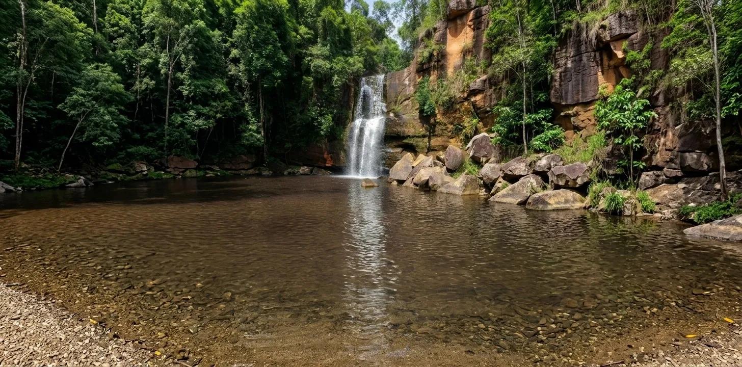 Poço da Cachoeirinha com pedras e mata ao redor e a queda d’água ao fundo